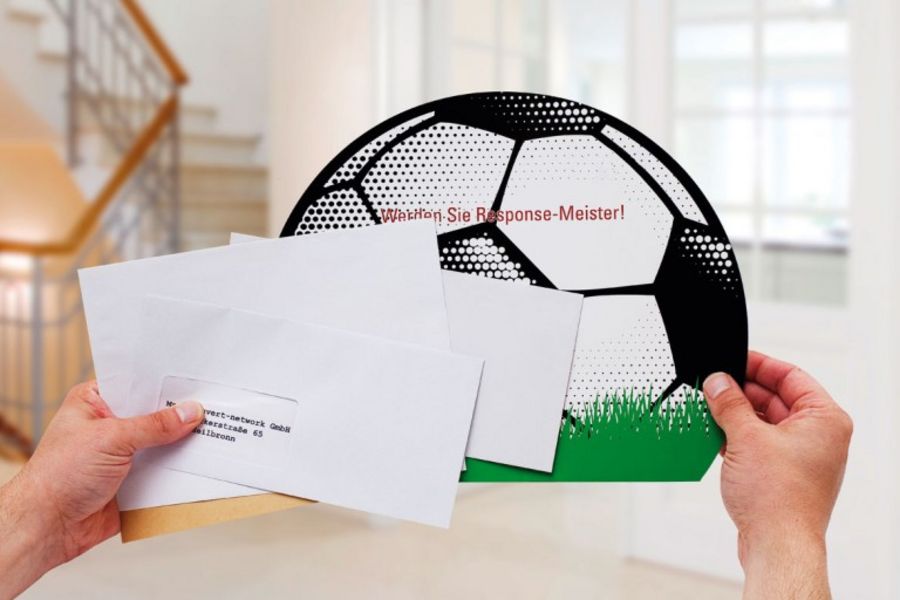 Ein Briefumschlag als Fußball gestaltet hebt sich ab vom täglichen Poststapel Ein Briefumschlag als Fußball gestaltet hebt sich ab vom täglichen Poststapel