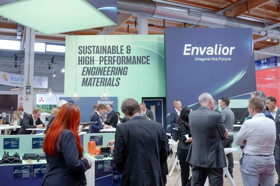 Fachbesucher an einem Messestand mit technischen Kunststoffbauteilen auf der Fakuma in Friedrichshafen