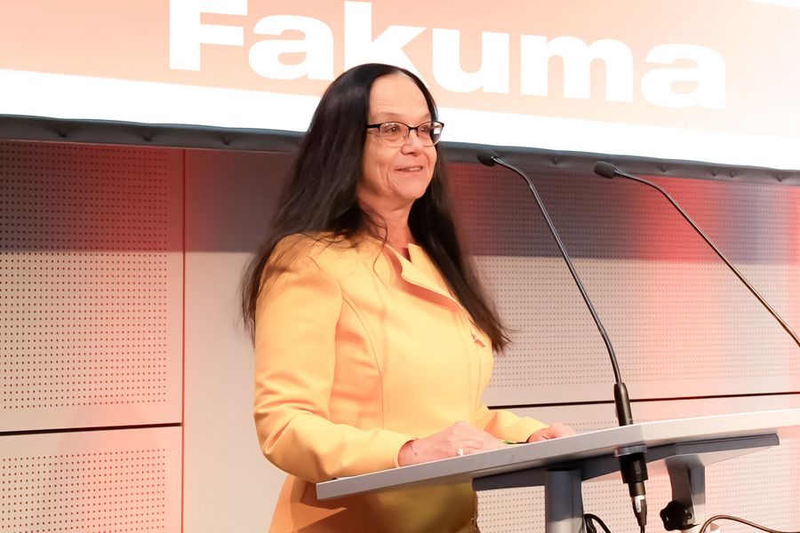 Rednerin bei einer Pressekonferenz der Fakuma vor einem großen Fakuma-Schriftzug